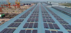 Aerial view of 5 MWp industrial solar panels installed on Sembcorp Marine shipyard roof in Tuas Singapore.
